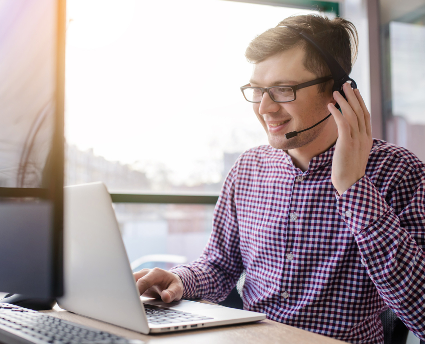 Side View Of It Professional Smiling While Holding Headset